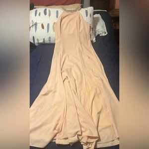 Pink gown, that has has a sparkly neck line, with a open back